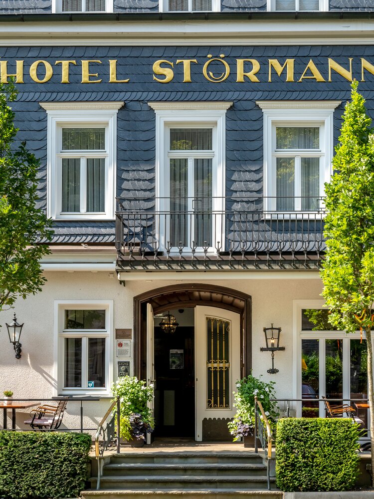 Nahe Ansicht der Eingangstür am Hotel Gebäude mit Stühlen und Tischen vor der Tür 