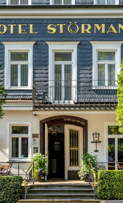 Nahe Ansicht der Eingangstür am Hotel Gebäude mit Stühlen und Tischen vor der Tür 