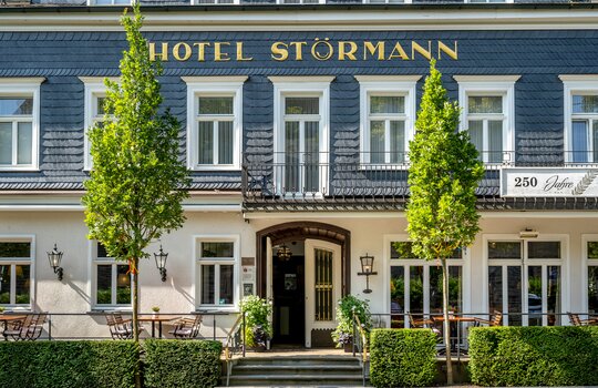 Nahe Ansicht der Eingangstür am Hotel Gebäude mit Stühlen und Tischen vor der Tür 