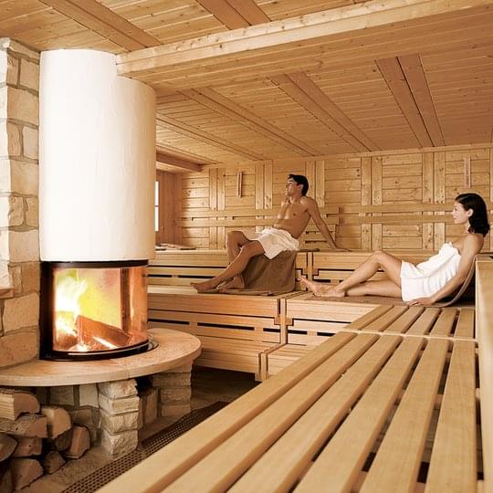 Zwei halbnackte Hotelgäste sitzen gemeinsam in der Sauna vom Hotel Deimann.