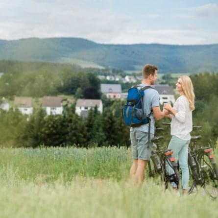 Radurlauber im Sauerland vor Dorfkulisse